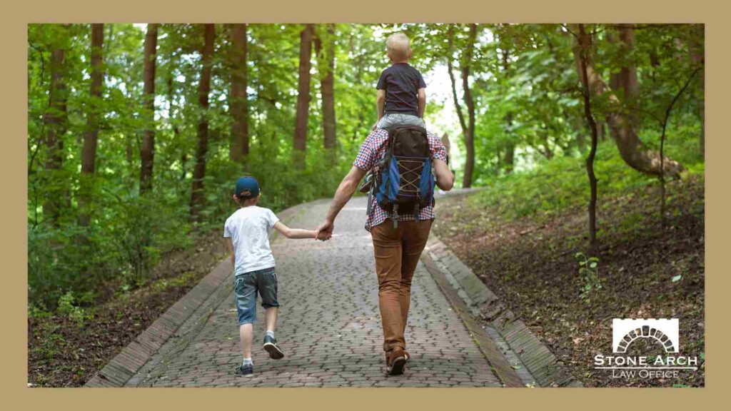 A dad with two small children in the woods near Bloomington, MN learning about guardians for minor children